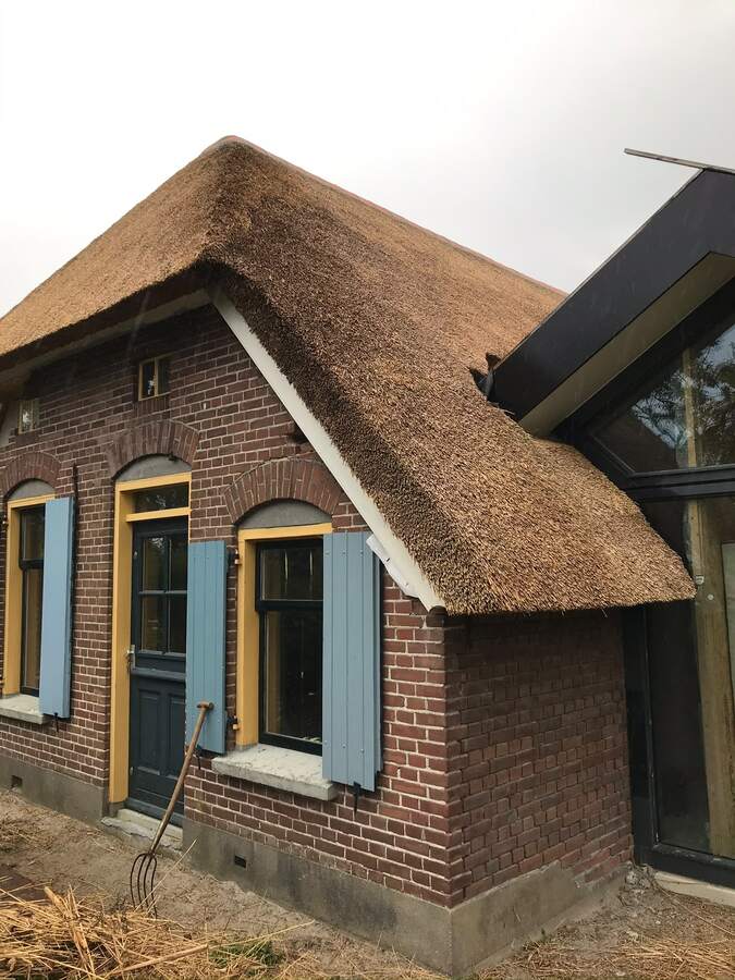 Rieten dak met blauwe luiken
